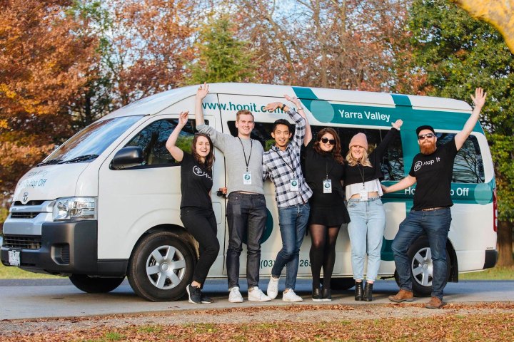 a group of people standing in front of a car